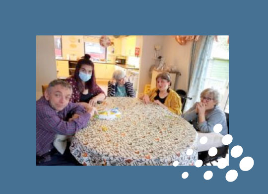 Group of individuals we support from Morely Road sitting at a kitchen table with support staff after receiving their CQC Inspection