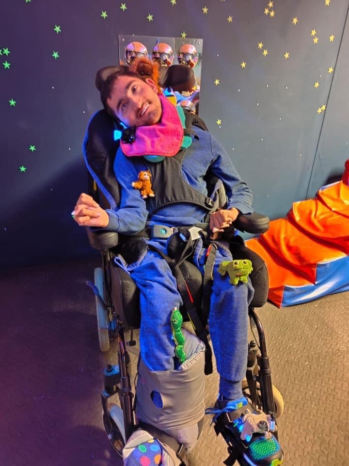 Male individual wheelchair user pictured in the sensory room of Cwmbran