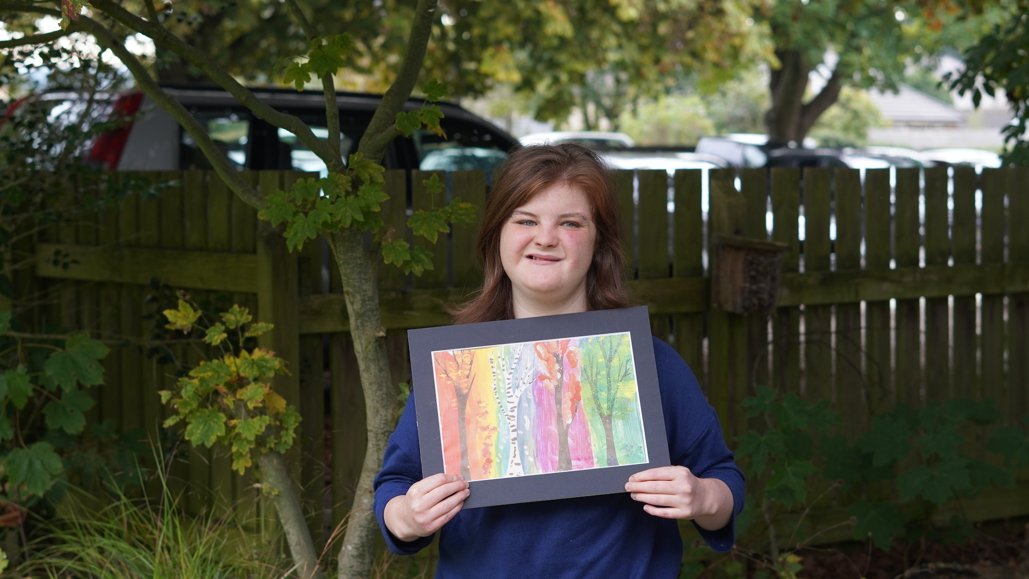 Isabelle with her artwork from Beaumont College who won an award at Unique Art Awards 2022