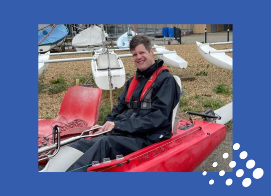 Matthew from New Road sitting in a canoe smiling because he received sailing certification