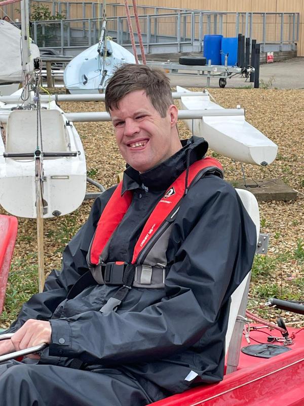 Matthew from New Road sitting in a canoe smiling because he received sailing certification